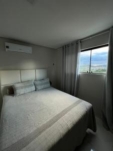 a bedroom with a large bed with a large window at Suite Master Casa Luz in Garanhuns