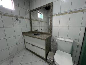 a bathroom with a toilet and a sink and a mirror at Suite Master Casa Luz in Garanhuns