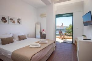 a bedroom with a large bed and a balcony at Villa Calliope Lardos in Lartos +41 photos