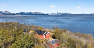 a red house on the shore of a body of water at Bamsen hytte in Evenskjer