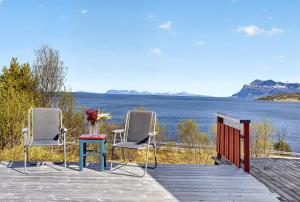 two chairs and a table on a dock with the water at Bamsen hytte in Evenskjer