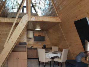 a kitchen with a table and chairs in a loft at Aframe Bradu in Bradu