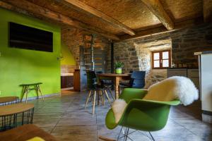 a room with green walls and tables and chairs at Gorge du Tarn Loft Cocoon Lesoleilo in Mostuéjouls +5 photos