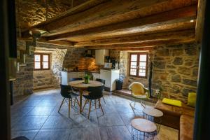 a kitchen with a table and chairs in a room at Gorge du Tarn Loft Cocoon Lesoleilo in Mostuéjouls
