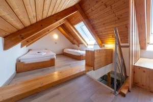 ein Dachzimmer mit zwei Betten und einer Treppe in der Unterkunft JBX Albatros Lipno in Přední Výtoň