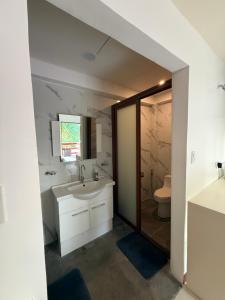 a bathroom with a sink and a toilet at Villa Virtud Beach Resort in Alegria