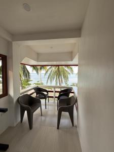 a room with chairs and a view of the ocean at Villa Virtud Beach Resort in Alegria