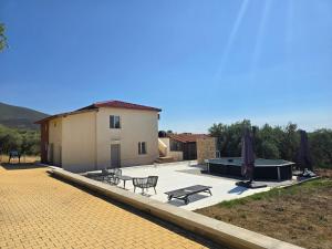 a patio with tables and umbrellas next to a building at Olive Hill Guest House in Limenas