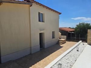 a house with a patio next to a building at Olive Hill Guest House in Limenas