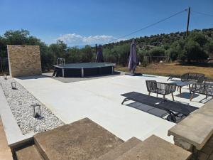 a ping pong table and chairs on a patio with a table and a ping at Olive Hill Guest House in Limenas +56 photos