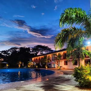 a villa with a swimming pool at night at Tantiri River Resort in Puerto Maldonado