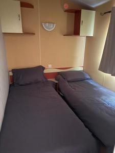 two beds in a small room next to each other at Sous les étoiles de St georges in Lazer