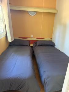 two beds sitting next to each other in a room at Sous les étoiles de St georges in Lazer