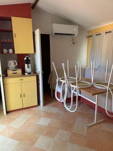 a room with chairs and a table and a kitchen at Sous les étoiles de St georges in Lazer