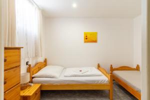 a small bedroom with two beds and a window at Déli Terasz A Apartman Free parking, self-check-in anytime in Győr