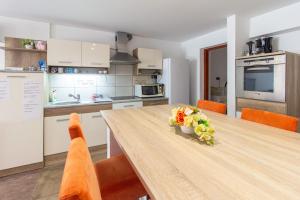 a kitchen with a wooden table and orange chairs at Déli Terasz A Apartman Free parking, self-check-in anytime in Győr