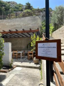 a sign on a pole next to a patio at Albatros Apartments in Licata