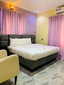 a bedroom with two beds and pink curtains at Excellence Citizens Hotel and Resort in Ilorin
