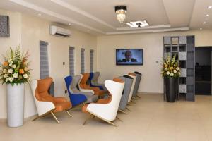 a waiting room with chairs and a tv on the wall at Excellence Citizens Hotel and Resort in Ilorin