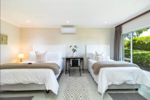 two beds in a bedroom with a desk and a window at Mon Rêve Estate in Cape Town +53 photos