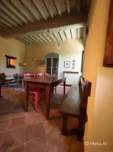 a dining room with a wooden table and a bench at Casa Amiata in Sarteano