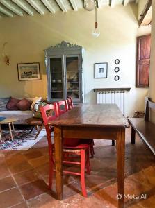 a dining room with a wooden table and red chairs at Casa Amiata in Sarteano +13 photos