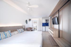 a bedroom with a white bed and a television at Serenity Apartments in Port d'Alcudia +23 photos