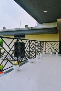 a balcony with white potted plants under a bridge at Xsquare Hotel in Garubhāsa