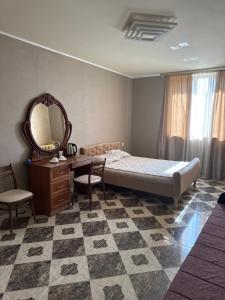 a bedroom with a bed and a desk and a mirror at gest house in Pʼarakʼar