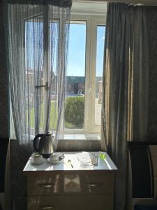 a room with a window and a table with a lamp at gest house in Pʼarakʼar