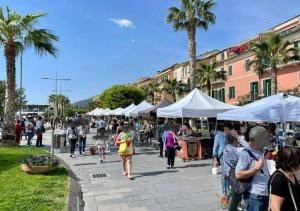 a group of people walking around a market with tents at 200m from Beach, New Central Apt, AC, WiFi in Loano