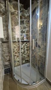 a shower in a bathroom with a stone wall at La casetta in Trabia