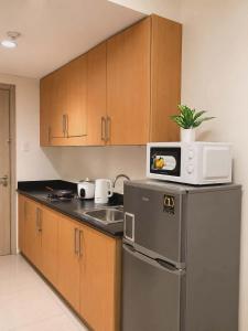 a kitchen with a microwave on top of a refrigerator at Shore 1 Tower D in Manila