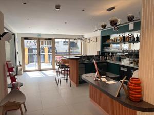 a kitchen with a counter with chairs and a bar at Apparté Plus in Brive-la-Gaillarde