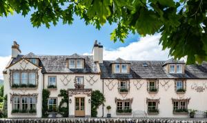 a large white house with a gray roof at The Loch Lomond Arms Hotel in Luss