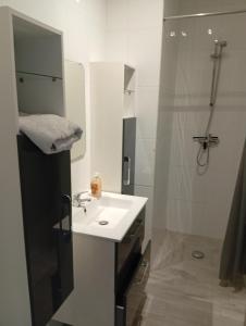 a white bathroom with a sink and a shower at Fernand Villard in La Souterraine
