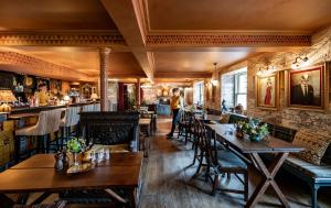 a restaurant with wooden tables and chairs and a bar at The Loch Lomond Arms Hotel in Luss