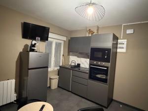 a kitchen with stainless steel appliances and a refrigerator at L'Escapade Normande in Caen