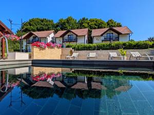 ein Haus mit Stühlen und einem Wasserbecken in der Unterkunft PALLOS Retreat & Wellness in Sovata