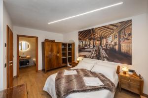 a bedroom with a bed and a painting on the wall at B&B Soreghina in Malè