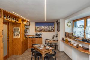 a kitchen and dining room with a table and chairs at B&B Soreghina in Malè