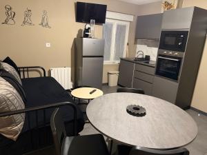 a living room with a table and a kitchen at L'Escapade Normande in Caen