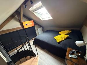 a bedroom with a bed with a yellow pillow on it at L'Escapade Normande in Caen