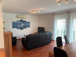 a living room with black leather furniture and a table at Apartments Kivi in Novigrad Istria