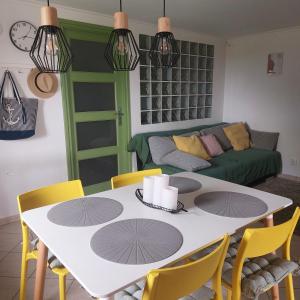 a living room with a white table and yellow chairs at Panorama Wine & Chill in Hévíz