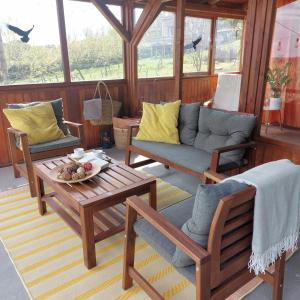a porch with a couch and chairs and a table at Panorama Wine & Chill in Hévíz