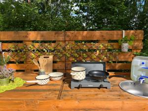 a grill with pots and pans on a wooden table at Ilmjärve Glamping Otepää in Ilmjärve +8 photos
