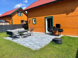 a patio with a bbq and a grill next to a house at Blockhaus Wassermann Spielberg in Spielberg