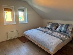 a bedroom with a bed in a room with two windows at Blockhaus Wassermann Spielberg in Spielberg