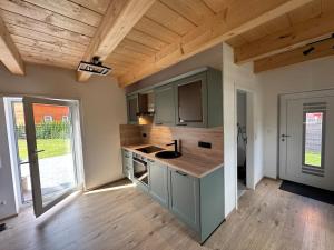a kitchen with green cabinets and a wooden ceiling at Blockhaus Wassermann Spielberg in Spielberg +4 photos
